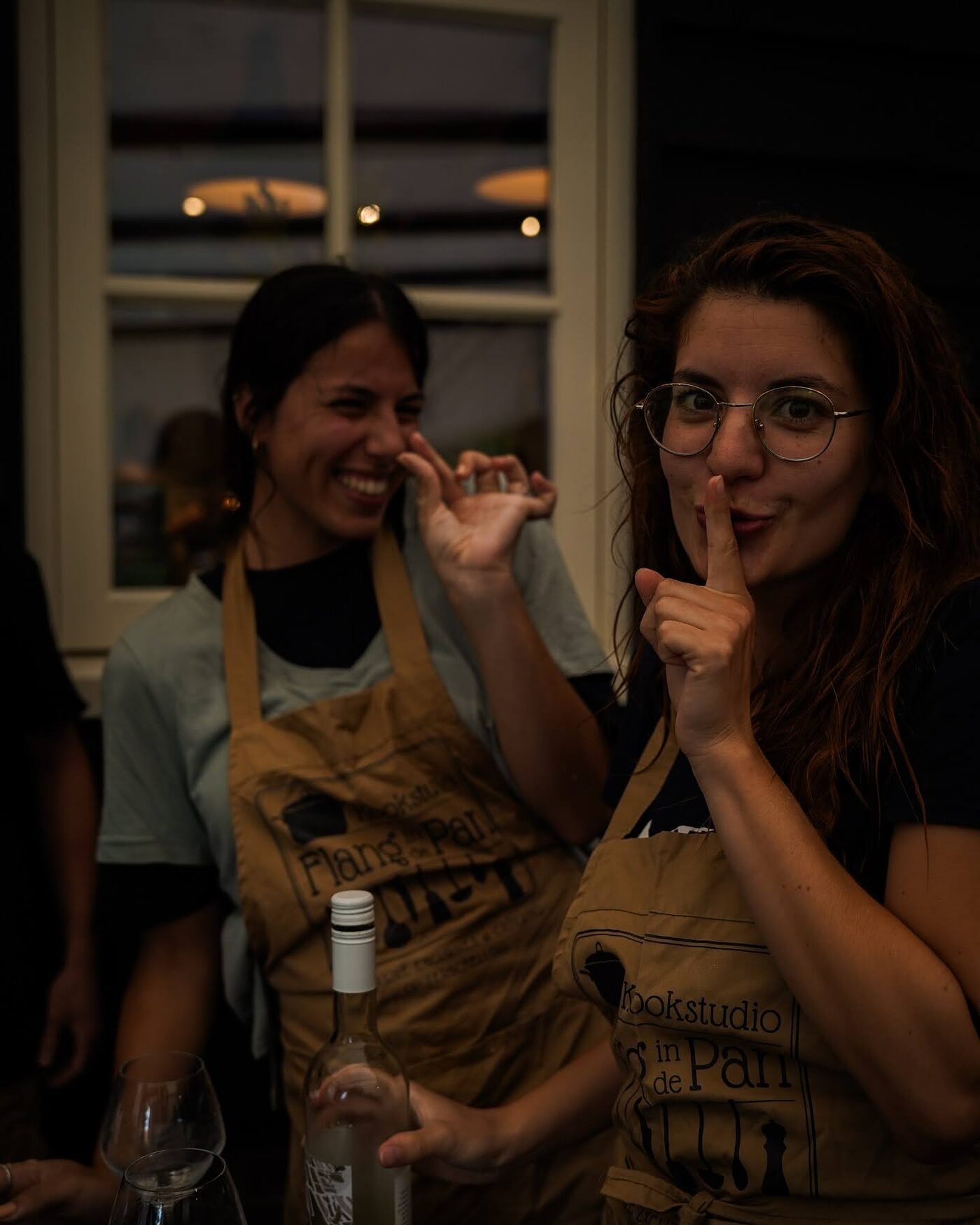 Two participants in aprons asking for silence