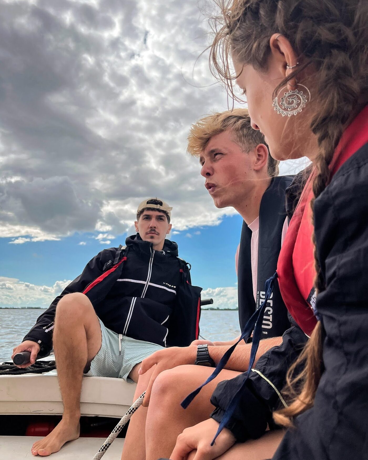 Participants chatting on a boat under a cloudy sky