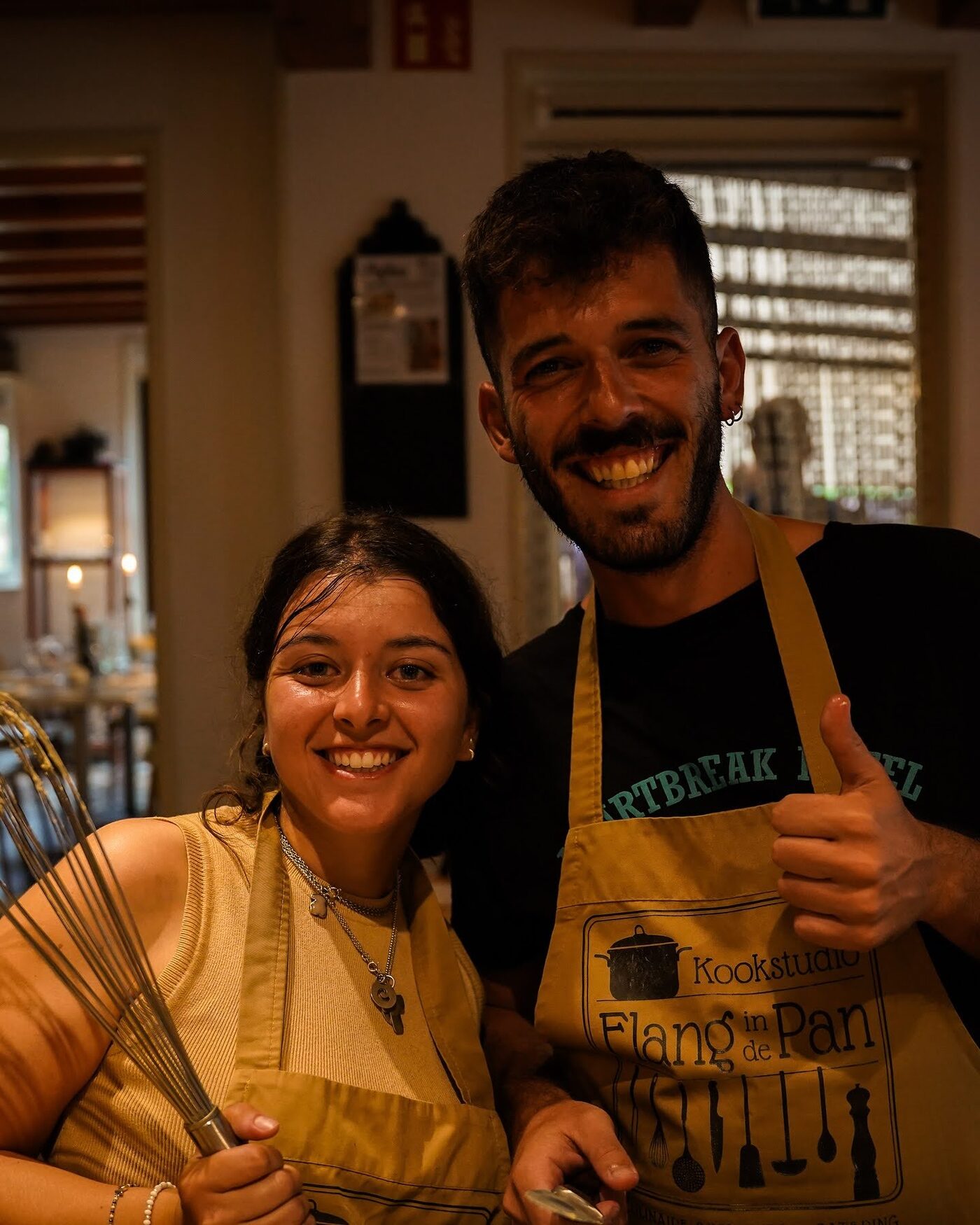 Two cooks in aprons smiling at the camera