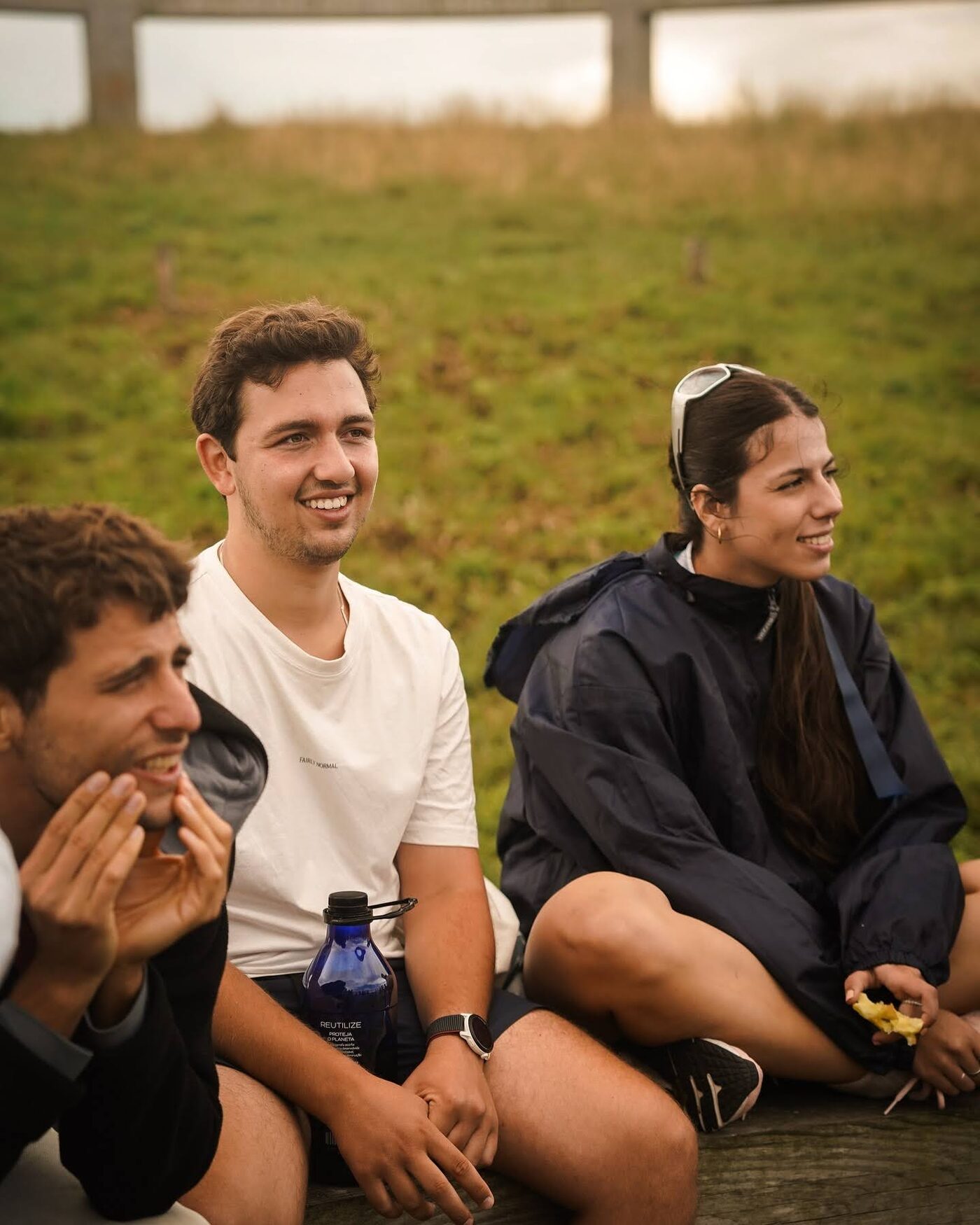 Three participants laughing together on the grass