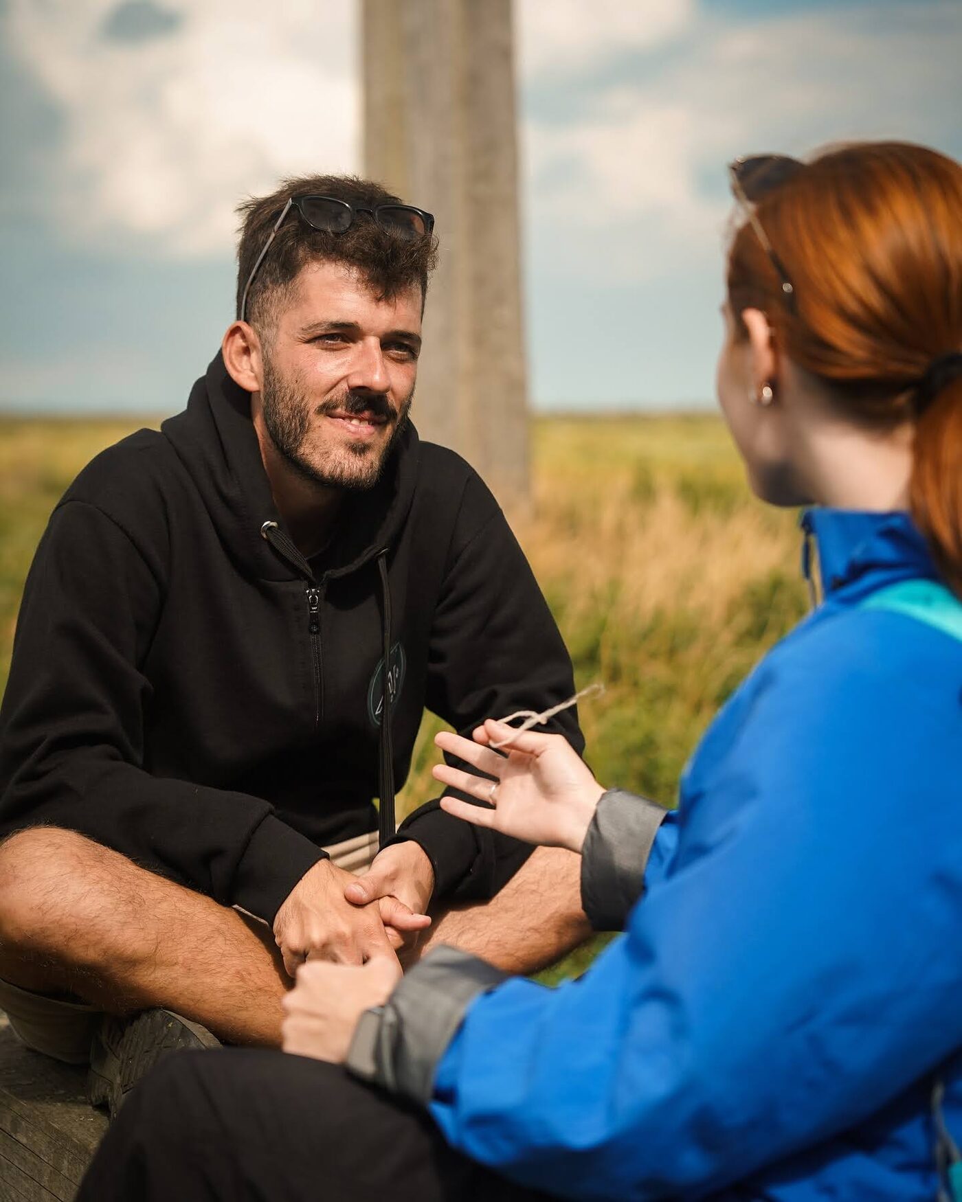 Two participants in conversation on the grass