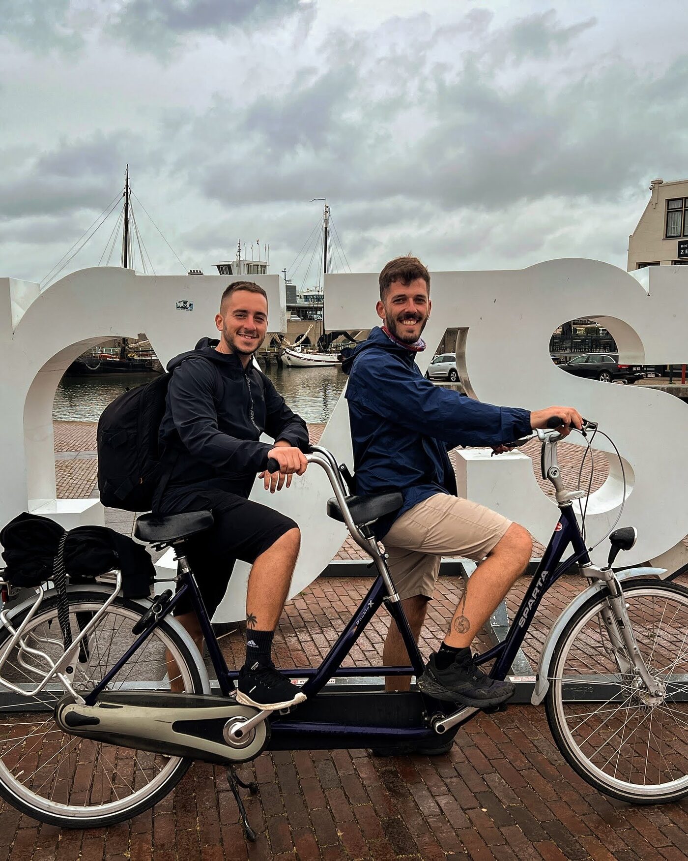 Two participants on a tandem bike on the deck of a ferry