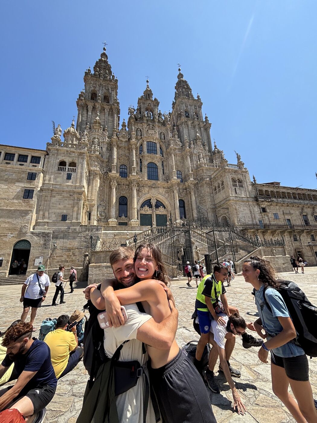 Two pilgrims hugging in front of Santiago cathedral