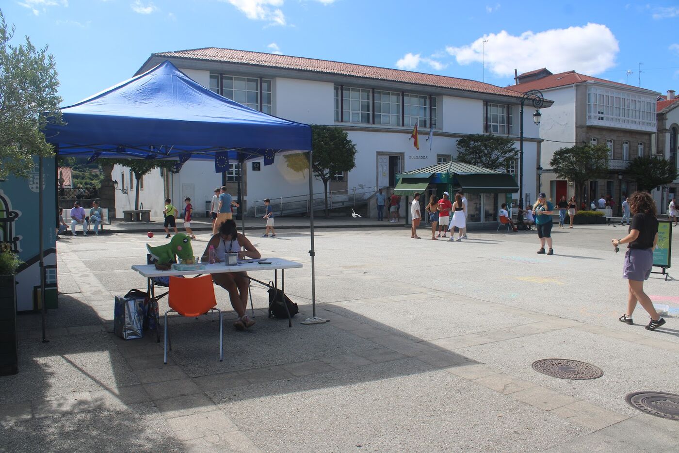A Human Library table under a blue tent in a town square