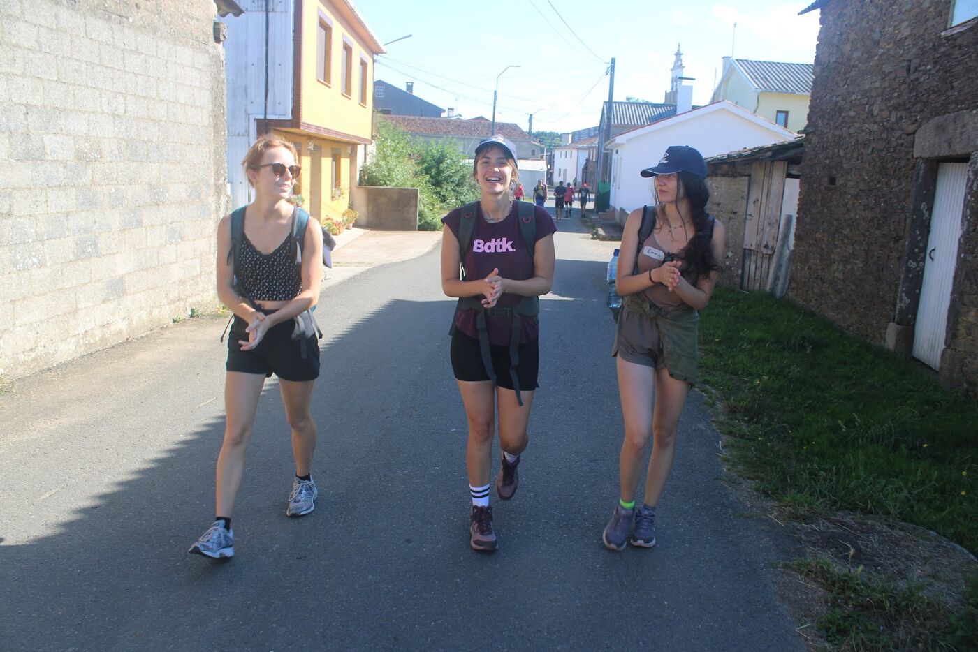 Three walkers coming down a village street